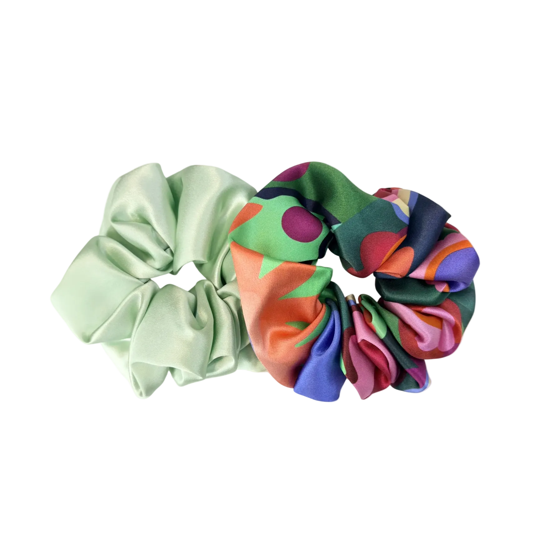 Two scrunchies, one green and one multicolored with polka dots, on a white background.